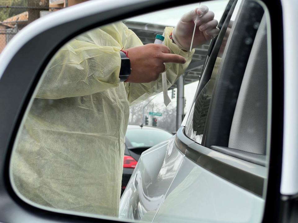 A technician performs a covid-19 test at Redwood High School on Tuesday morning in Visalia.