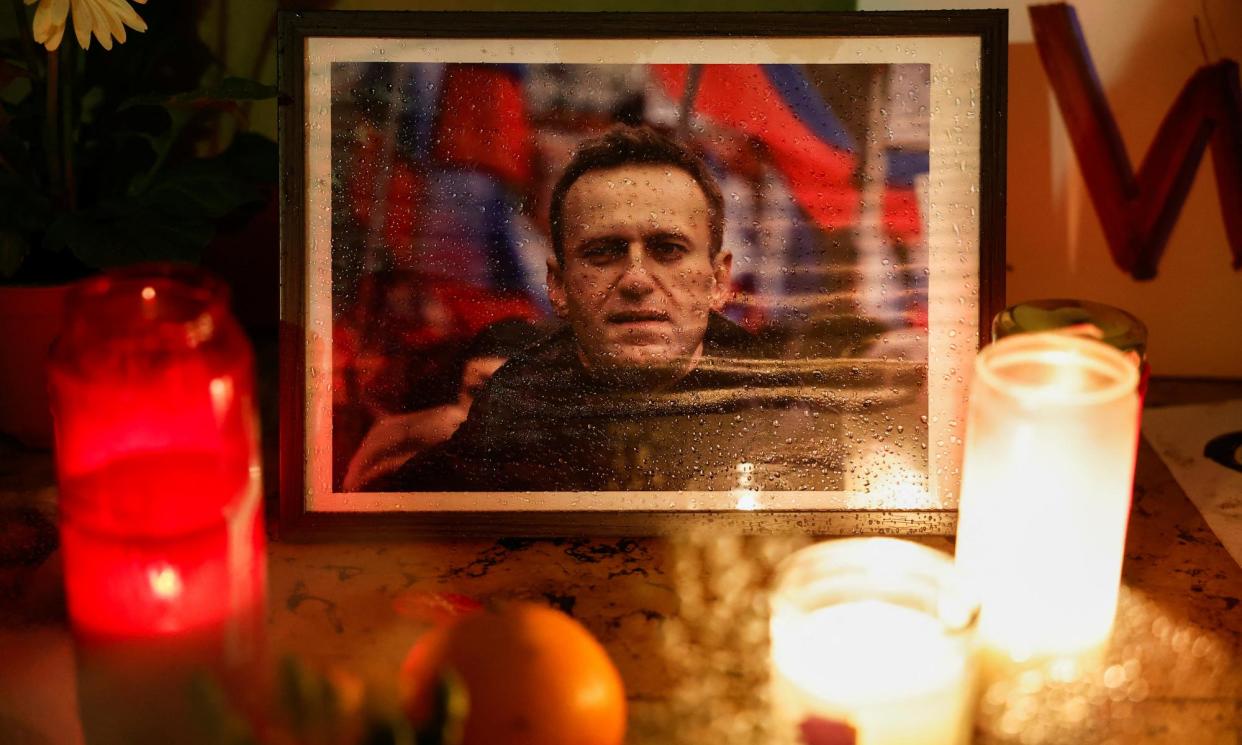 <span>Candles burn next to a portrait of Alexei Navalny at a vigil in Paris after his death.</span><span>Photograph: Benoît Tessier/Reuters</span>