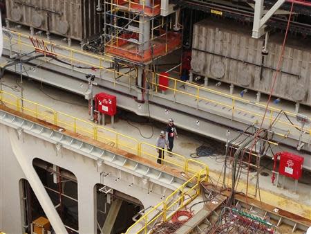 Two workers are seen as Chevron Corp assembles two ultramodern deepwater oil production platforms at a shipyard in Ingleside, Texas, September 20, 2013. REUTERS/Kristen Hays