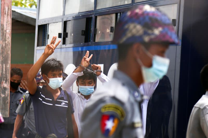 Members of the All Burma Federation of Students Union, gesture as they leave the court after a trial in Mandalay