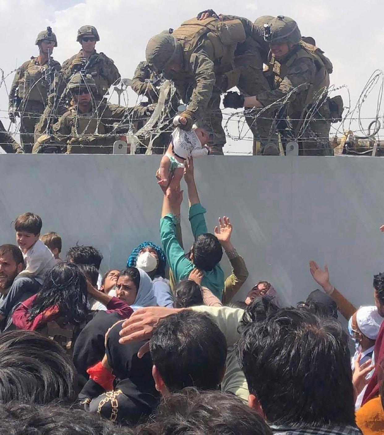 Afghan baby handed to Marine over fence