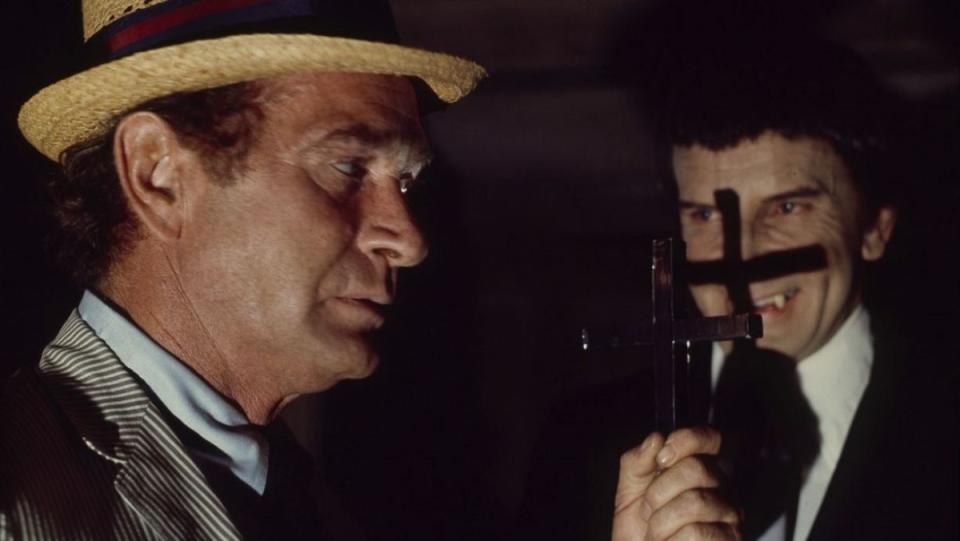 Carl Kolchak (Darren McGavin) holds up a cross to the face of vampire Janos Skorzeny in the horror TV movie The Night Stalker.