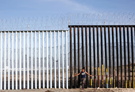 FILE PHOTO: Damaris Alejandra Tejeda, 15, a migrant from Honduras, part of a caravan of thousands traveling from Central America en route to the United States, poses in front of the border wall between the U.S. and Mexico in Tijuana, Mexico, November 23, 2018. REUTERS/Kim Kyung-Hoon