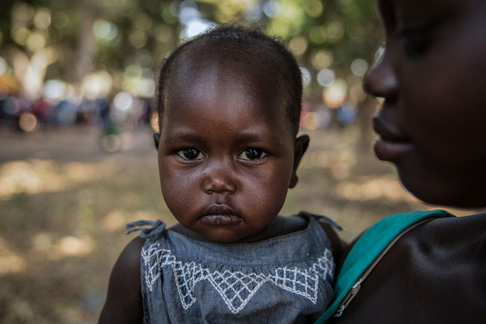 <p>Najat (R), 17, who was raped numerous times by a soldier, holds her one-year-old daughter Eva during a release ceremony for child soldiers in Yambio, South Sudan on Feb. 7, 2018. (Photo: Stefanie Glinski/AFP/Getty Images) </p>