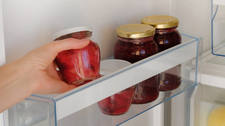 placing a jar of jam into the refridgerator