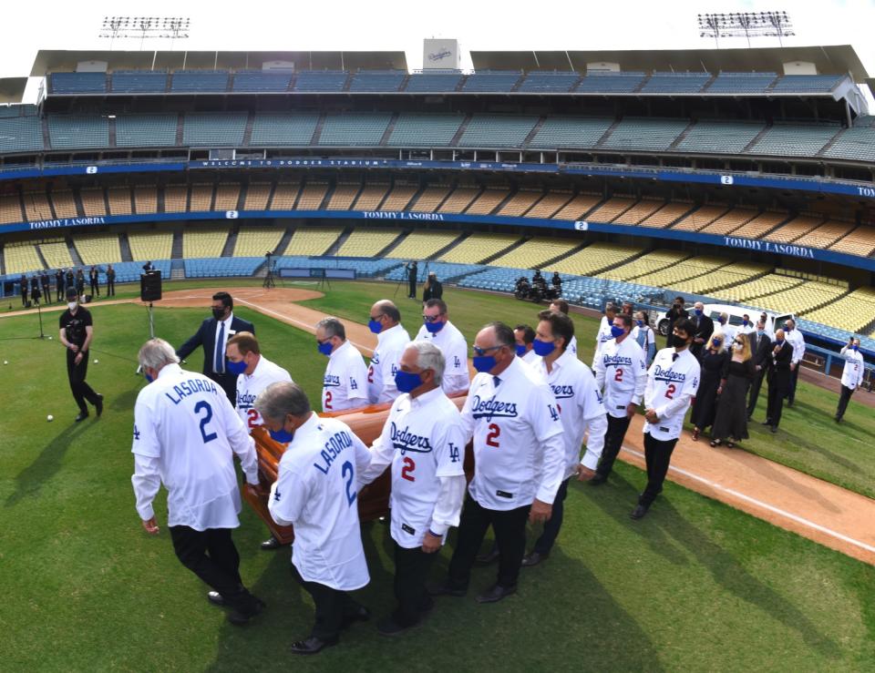 Pallbearers carry Tommy Lasaroda's casket at Dodger Stadium on January 19, 2021.