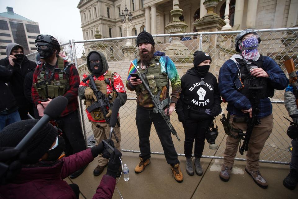 Apparent members of the Boogaloo Bois speak to media during a protest outside the Michigan State Capitol building in downtown Lansing on Sunday, Jan. 17, 2021.