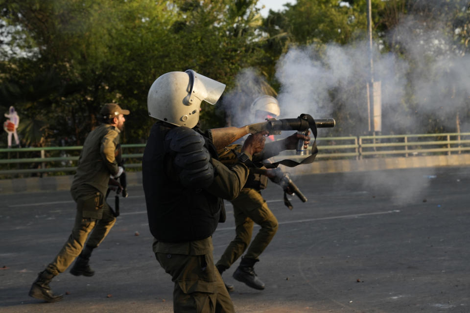 Police officers fire tear gas shells to disperse the supporters of Pakistan's former Prime Minister Imran Khan during clashes, in Lahore, Pakistan, Wednesday, March 8, 2023. Pakistani police used water cannons and fired tear gas to disperse supporters of the country's former Prime Minister Khan Wednesday in the eastern city of Lahore. Two dozen Khan supporters were arrested for defying a government ban on holding rallies, police said. (AP Photo/K.M. Chaudary)