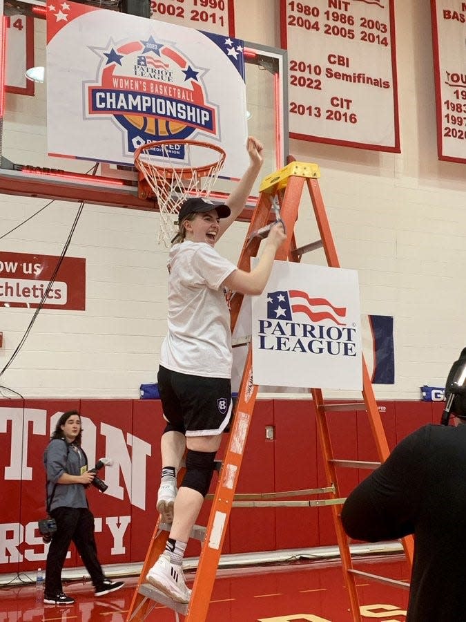 Holy Cross junior and Patriot League tourney MVP Bronagh Power-Cassidy takes her turn cutting down the net after the Crusaders won the Patriot League title with a win over top-seeded Boston University.