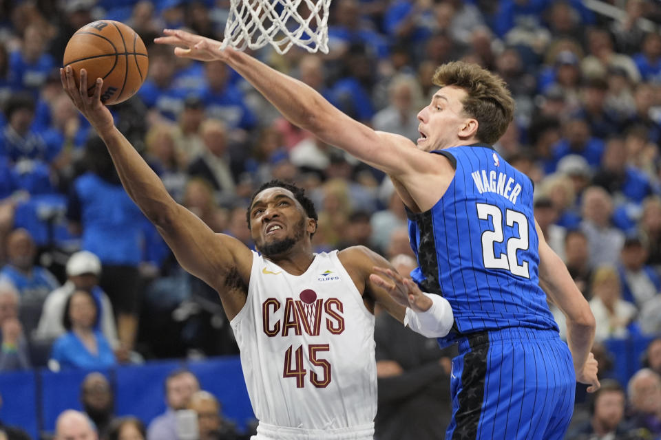 Cleveland Cavaliers guard Donovan Mitchell (45) takes a shot around Orlando Magic forward Franz Wagner (22) during the first half of Game 6 of an NBA basketball first-round playoff series, Friday, May 3, 2024, in Orlando, Fla. (AP Photo/John Raoux)