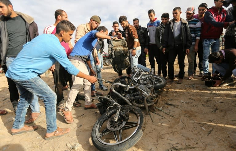 Palestinians with the remains of a motorcycle destroyed in an explosion in the Gaza Strip on December 12, 2017