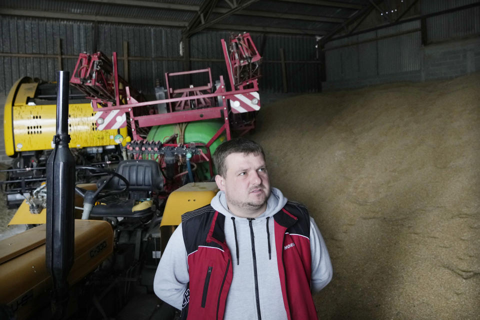 Piotr Korycki, a 34-year-old Polish farmer, stands in a warehouse filled with grain on his farm in Cywiny Wojskie, Poland, on Monday March 18, 2024. Piotr says his business has been badly destabilized by Russia’s war against Ukraine and that the European Union is only adding to his problems. He's among the large number of farmers who have protested across Europe for months, and he’s organizing the latest protest planned for Poland on Wednesday. (AP Photo/Czarek Sokolowski)