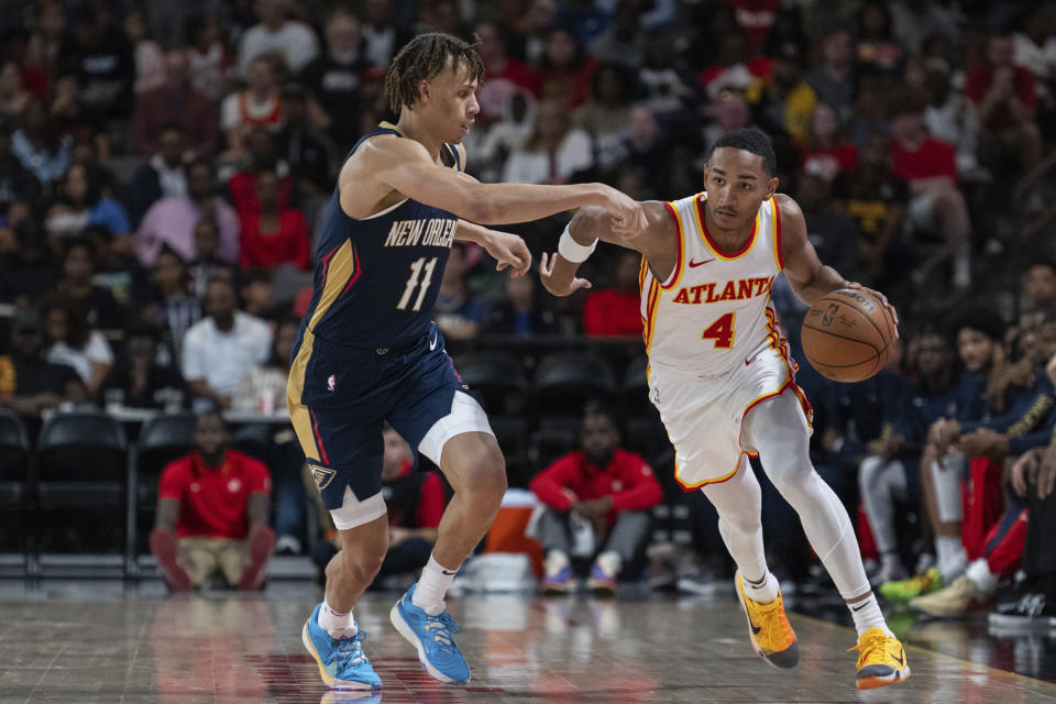 Atlanta Hawks guard Kobe Bufkin dribbles against New Orleans Pelicans guard Dyson Daniels (11) during the second half of a preseason NBA basketball game Saturday, Oct. 14, 2023, in College Park, Ga. (AP Photo/Hakim Wright Sr.)