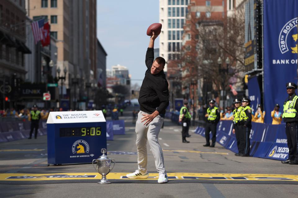 BOSTON, MASSACHUSETTS - APRIL 15: Boston Marathon grand marshal and former player for the New England Patriots Rob Gronkowski spikes a football next to the trophy during the 128th Boston Marathon on April 15, 2024 in Boston, Massachusetts.  (Photo by Paul Rutherford/Getty Images)