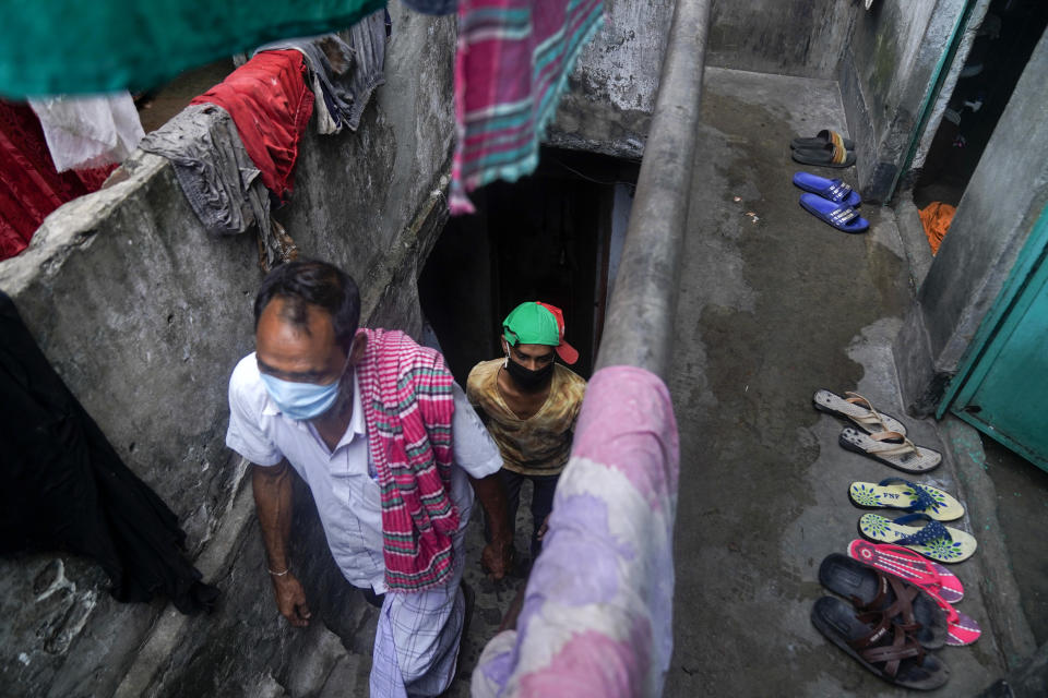 In this May 20, 2020, photo, provided by UNICEF, Mohammed Rakib, 15, who was accused of beating a man and sent to an overcrowded detention center, follows his father up the stairs to his home after being released, in Dhaka, Bangladesh. Authorities in Bangladesh have been releasing hundreds of children suspected of committing mostly petty crimes as they try to keep the coronavirus from spreading in overcrowded detention centers, officials said Friday. The orders for their release on bail came from virtual courts set up by the country's Supreme Court with the help of UNICEF, officials said. "It feels great to be freed and get united with my parents," Rakib told The Associated Press on Friday. "I am very happy. I have suffered in the jail a lot. That's a bad place." (UNICEF via AP)