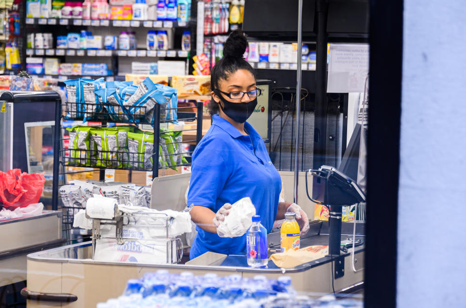 NEW YORK, NEW YORK - JUNE 30: A worker wears a face mask in Gristedes supermarket in Murray Hill as New York City moves into Phase 2 of re-opening following restrictions imposed to curb the coronavirus pandemic on June 30, 2020. Phase 2 permits the reopening of offices, in-store retail, outdoor dining, barbers and beauty parlors and numerous other businesses. Phase 2 is the second of four phased stages designated by the state. (Photo by Noam Galai/Getty Images)