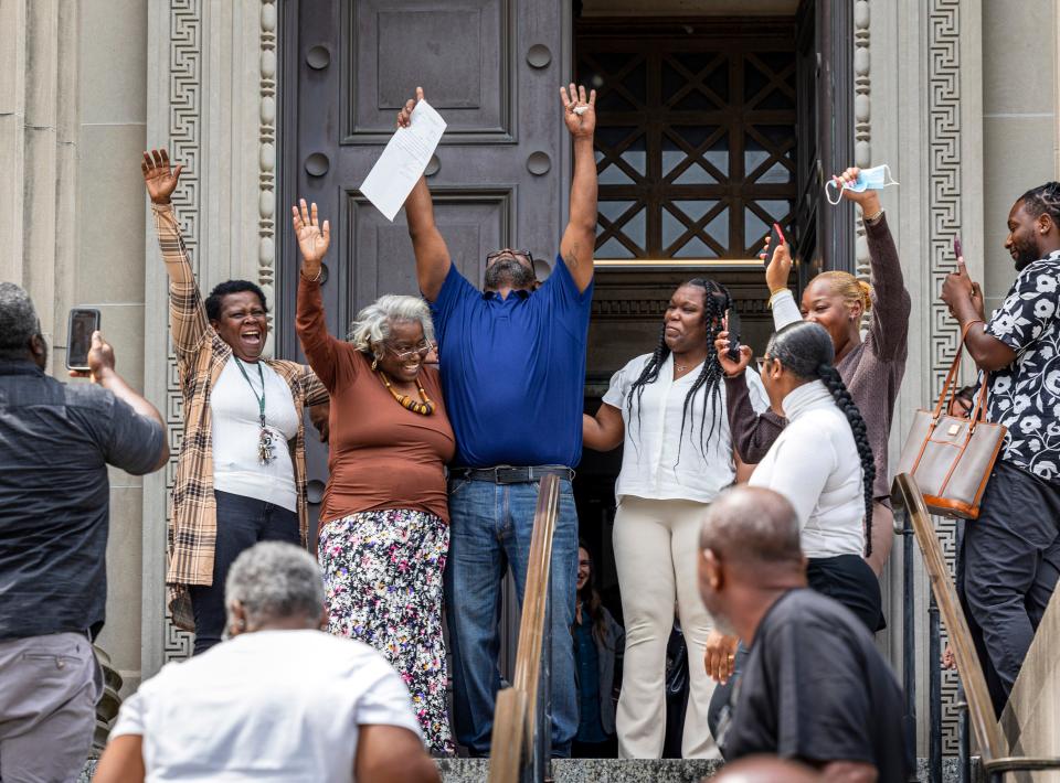 Patrick Brown, center in blue, raises his arms as he walks out a free man from Criminal District Court on Monday, May 8, 2023 in New Orleans after 20 years in jail for a rape the victim/survivor says he did not commit.