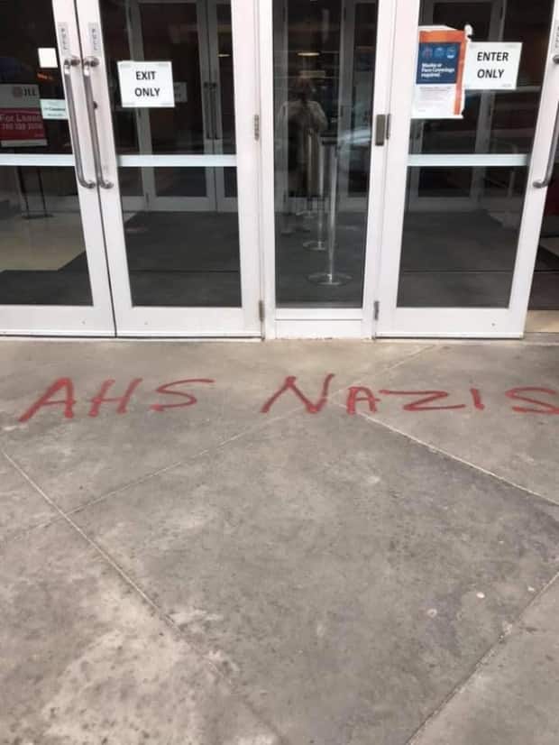 Employees found graffiti outside AHS offices Friday morning in Edmonton by the Plaza 124 building on 124 Street and 102 Ave. (davecedm/Reddit - image credit)