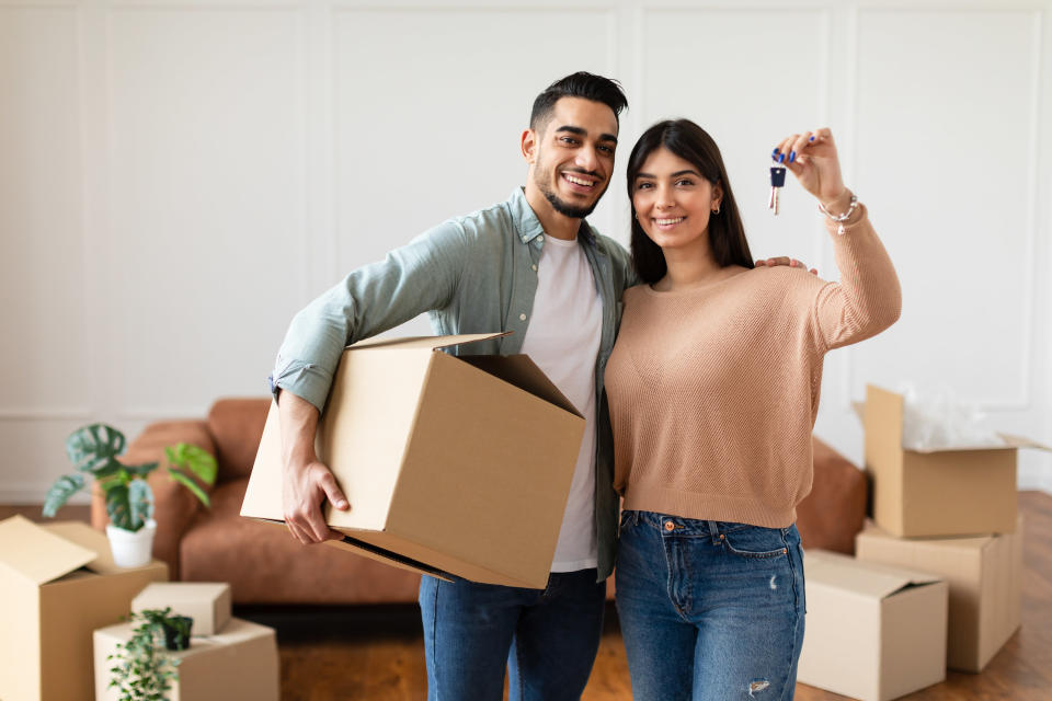 a couple moving and holding the keys to a house