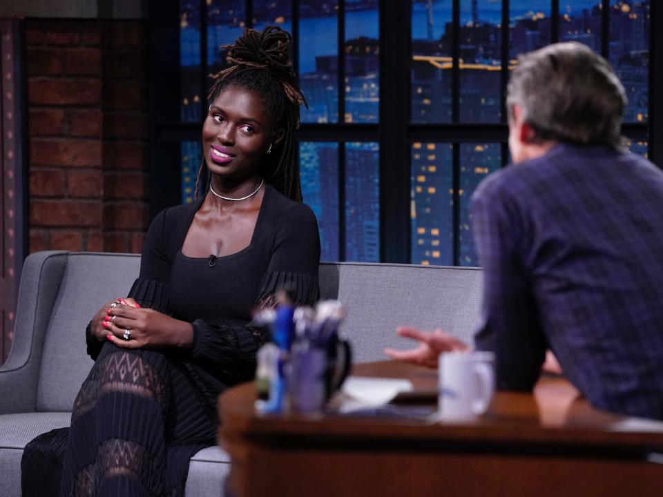 Jodie Turner-Smith sits on Seth Meyers' couch during an episode of "Late Night" as the host asks her a question.