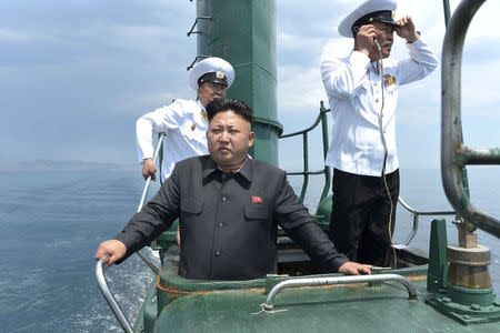 Kim Jong Un stands on the conning tower of a submarine during his inspection of the Korean People's Army Naval Unit 167 in this undated photo released June 16, 2014. REUTERS/KCNA