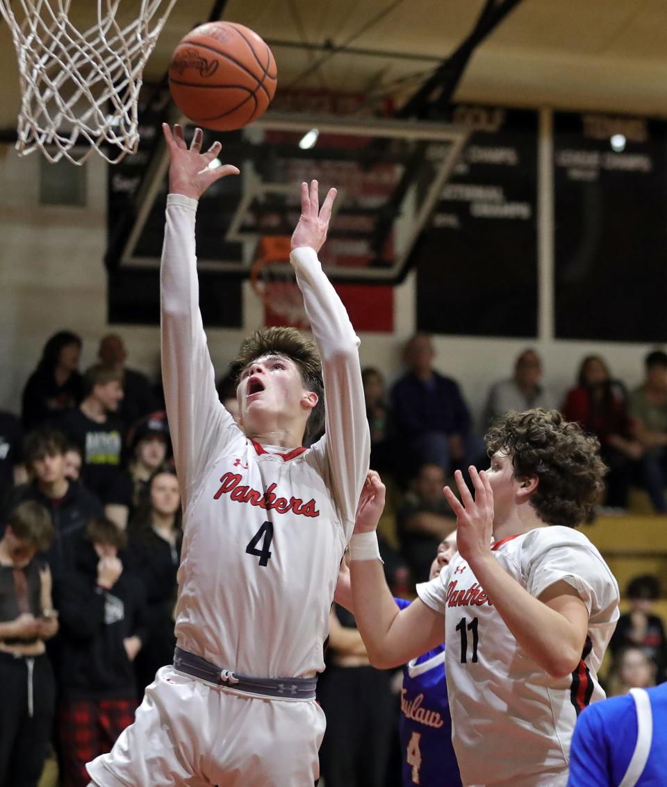 Manchester guard Brady Johnson, left, shoots in front of Ian Galloway during the second half of the Manchester Panthers final basketball game in the old Manchester High School gymnasium, Tuesday, Feb. 20, 2024, in New Franklin, Ohio.