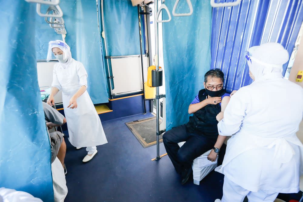 Members of the public receive their Covid-19 jab aboard a RapidPenang bus, which doubles as a mobile vaccination centre at Sekolah Kebangsaan Pai Chai, Batu Feringghi July 28, 2021. — Picture by Sayuti Zainudin