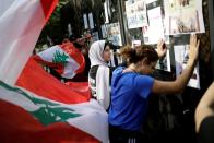 Protesters hit the fencing as they demonstrate outside of Lebanon Central Bank during ongoing anti-government protests in Beirut