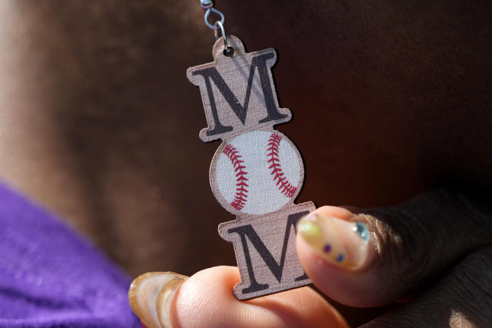 Sheila Moreno wears baseball themed earrings as she sits in the stands where her son Jadin is playing for Prairie View A&M University at the Andre Dawson Classic tournament, Friday, Feb. 23, 2024, at the Jackie Robinson Training Complex, in Vero Beach, Fla.The percentage of Black major league players has been declining for decades and remains historically low, but there are signs of improvement in the league's player development pipeline. (AP Photo/Lynne Sladky)