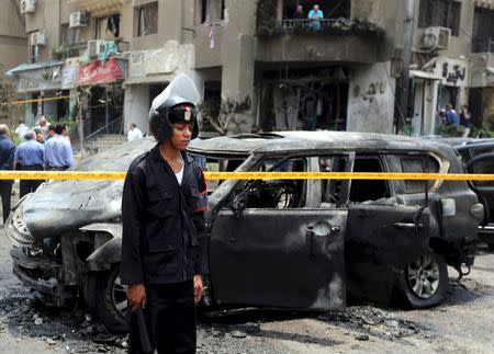 Policemen investigate the scene of a car bomb attack on the convoy of Egyptian public prosecutor Hisham Barakat near his house at Heliopolis district in Cairo, Egypt, in this June 29, 2015 file photo. REUTERS/Mohamed Abd El Ghany/Files