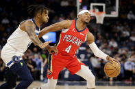 New Orleans Pelicans guard Devonte' Graham (4) drives against Minnesota Timberwolves guard D'Angelo Russell (0) in the first half of an NBA basketball game, Monday, Oct. 25, 2021, in Minneapolis. (AP Photo/Andy Clayton-King)