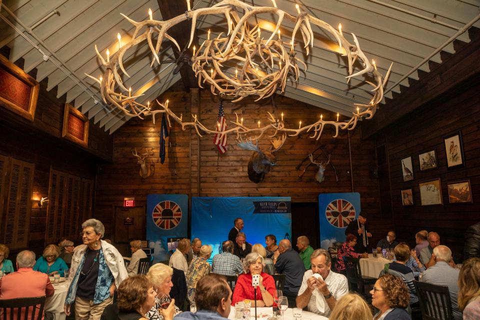 People sit for dinner inside Camp Ticonderoga during the Magic Soiree in Troy on Saturday, Sept. 30, 2023.