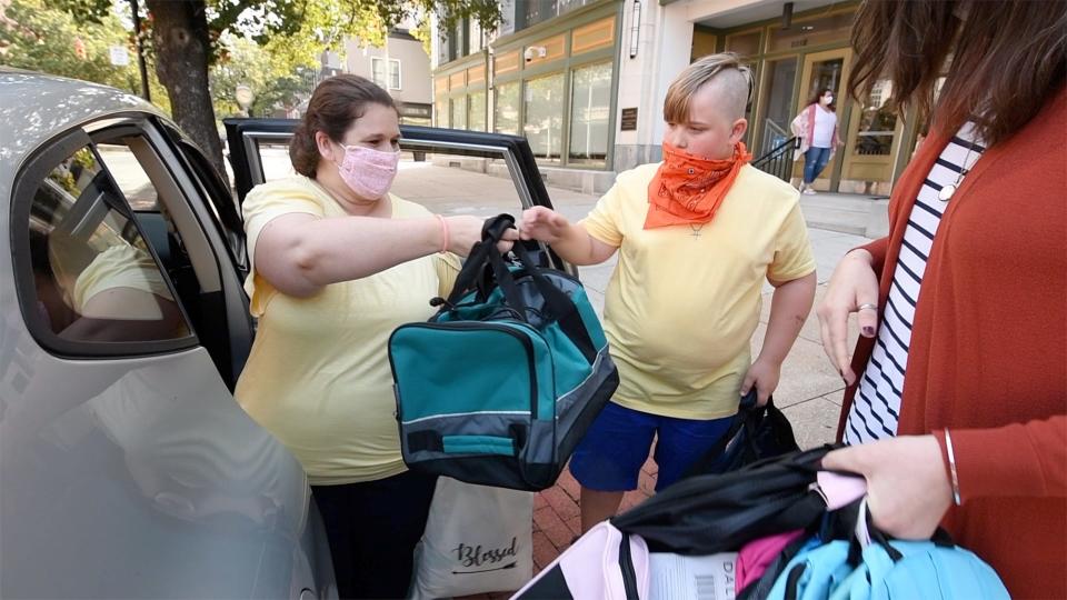 Mother Devon Brogan, left, helps Curvin Coxen unload gift bags in front of the York County Office of Children, Youth & Families.