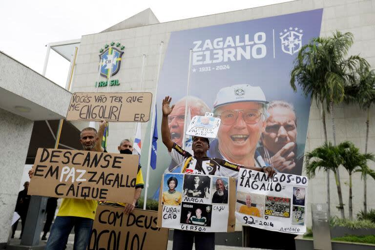 Aficionados del exjugador y seleccionador de Brasil Mario Zagallo sostienen pancartas afuera de las instalaciones de la Confederación de Brasil en donde se realizó el funeral de Zagallo, el domingo 7 de enero