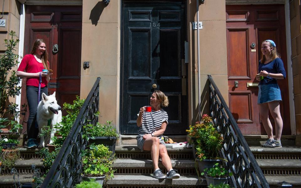 Neighbours in the Queen's Park area of Glasgow, Scotland, enjoy the warm weather - James Chapelard