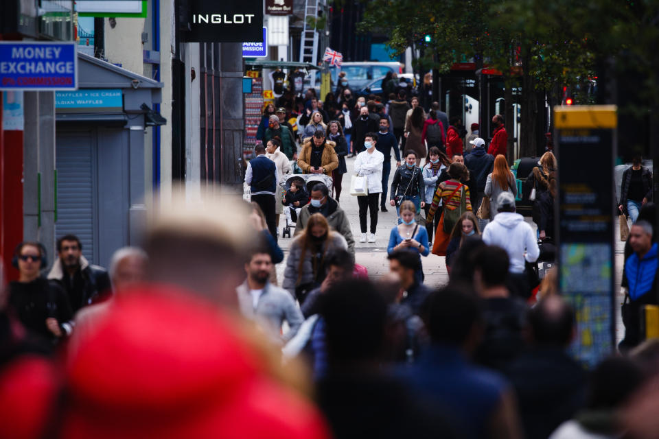 Shoppers, some wearing face masks, walk along Oxford Street in London, England. Photo by David Cliff/NurPhoto via Getty Images