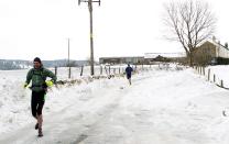 Runners brave the snow in Sutton, Cheshire. The cold weather is likely to continue to Easter weekend, although the Met office has not forecast a white Easter (PA)