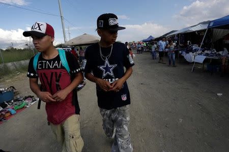 Jaziel and Plasma, both attending the meetings of Raza Nueva in Christ, a project of the archdiocese of Monterrey, tour a flea market in the municipality of Juarez, on the outskirts of Monterrey, Mexico, June 25, 2016. REUTERS/Daniel Becerril