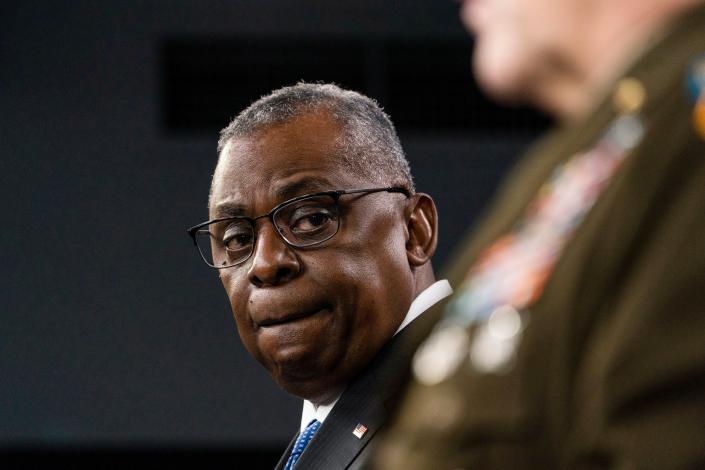 Secretary of Defense Lloyd Austin turns to Joint Chiefs Chairman Gen. Mark Milley as he speaks during a media briefing at the Pentagon, Friday, Jan. 28, 2022, in Washington. (AP Photo/Alex Brandon)