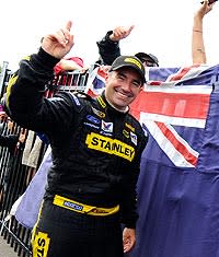 Australian-born Marcos Ambrose celebrates his first career Cup victory next to his native flag