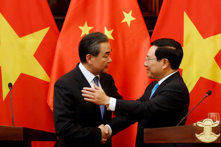 China's State Councilor and Foreign Minister Wang Yi (L) chats with Vietnam's Deputy Prime Minister and Foreign Minister Pham Binh Minh after a news conference at the Government Guesthouse in Hanoi, Vietnam April 1, 2018. REUTERS/Kham