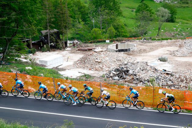 The pack rides past the ruins of the Rigopiano Hotel in Farindola during the 10th stage between Penne and Gualdo Tadino during the 101st Giro d'Italia, Tour of Italy cycling race, on May 15, 2018. The Rigopiano Hotel was overwhelmed by an avalanche on January 18, 2017 killing 29 people. (Photo by Luk Benies / AFP)        (Photo credit should read LUK BENIES/AFP via Getty Images) (Photo: LUK BENIES via AFP via Getty Images)