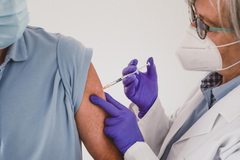 Close-up of a doctor giving a vaccination to an elderly patient. 