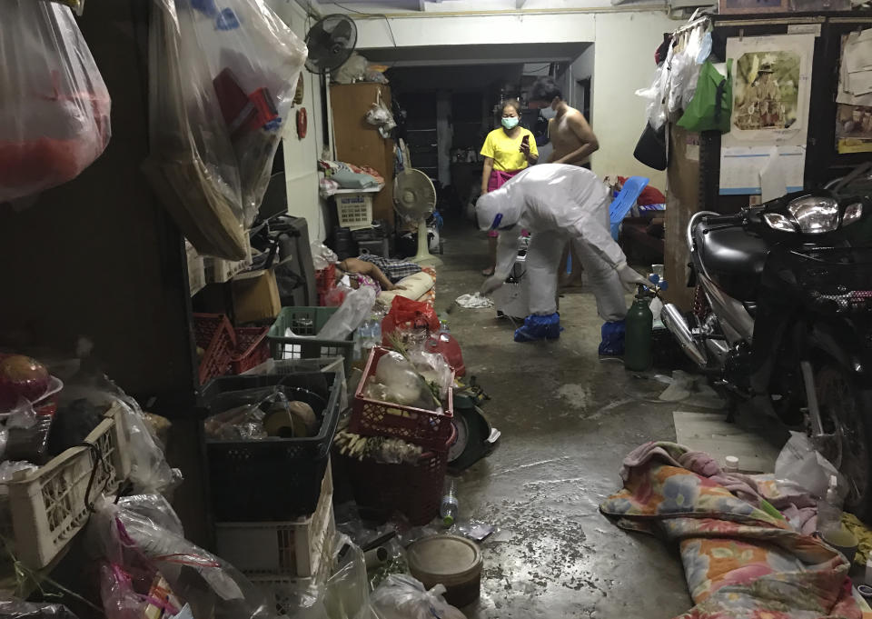 A volunteer from the "Saimai Will Survive" group in protective gear enters the home of an COVID-19-infected family Friday, July 23, 2021, in Bangkok, Thailand. As Thailand's medical system struggles beneath a surge of coronavirus cases, ordinary people are helping to plug the gaps, risking their own health to bring care and supplies to often terrified, exhausted patients who've fallen through the cracks. (AP Photo/Tassanee Vejpongsa)