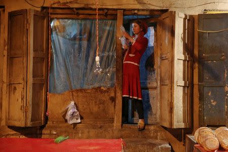 An ethnic Uighur woman stands in the door of a bakery in the old town of Kashgar, Xinjiang Uighur Autonomous Region, China, March 22, 2017. REUTERS/Thomas Peter