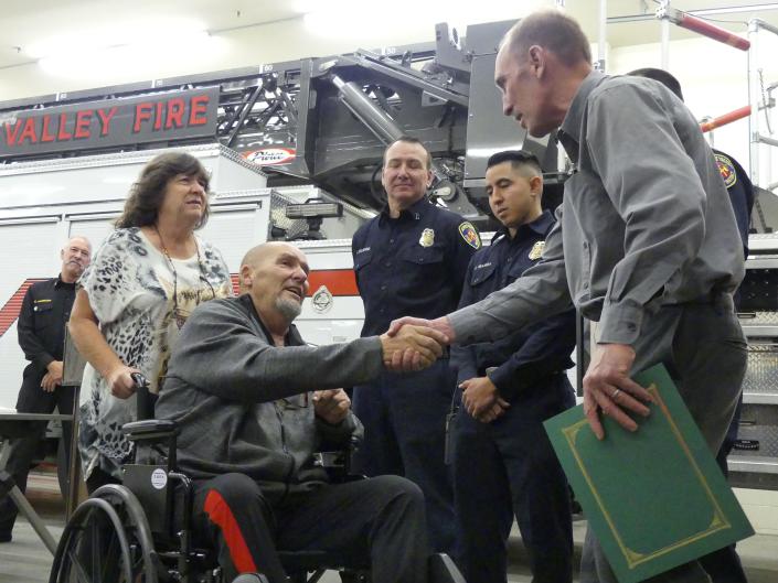 Randy Henson, 65, shakes hands with the paramedics of the Apple Valley Fire Protection District who helped save his life after falling off a ladder.