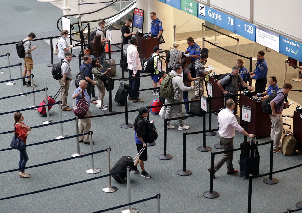 FILE- In this June 21, 2018 photo air passengers heading to their departure gates enter TSA pre-check before going through security screening at Orlando International Airport, in Orlando, Fla. Investigators were unable to corroborate specific allegations that a Transportation Security Administration supervisor instructed air marshals to racially discriminate against passengers at Florida's busiest airport. But investigators for the Department of Homeland Security's Office of Inspector General uncovered other concerns about racial profiling of passengers by other TSA supervisors at Orlando International Airport, according to a report sent to lawmakers last week. (AP Photo/John Raoux)