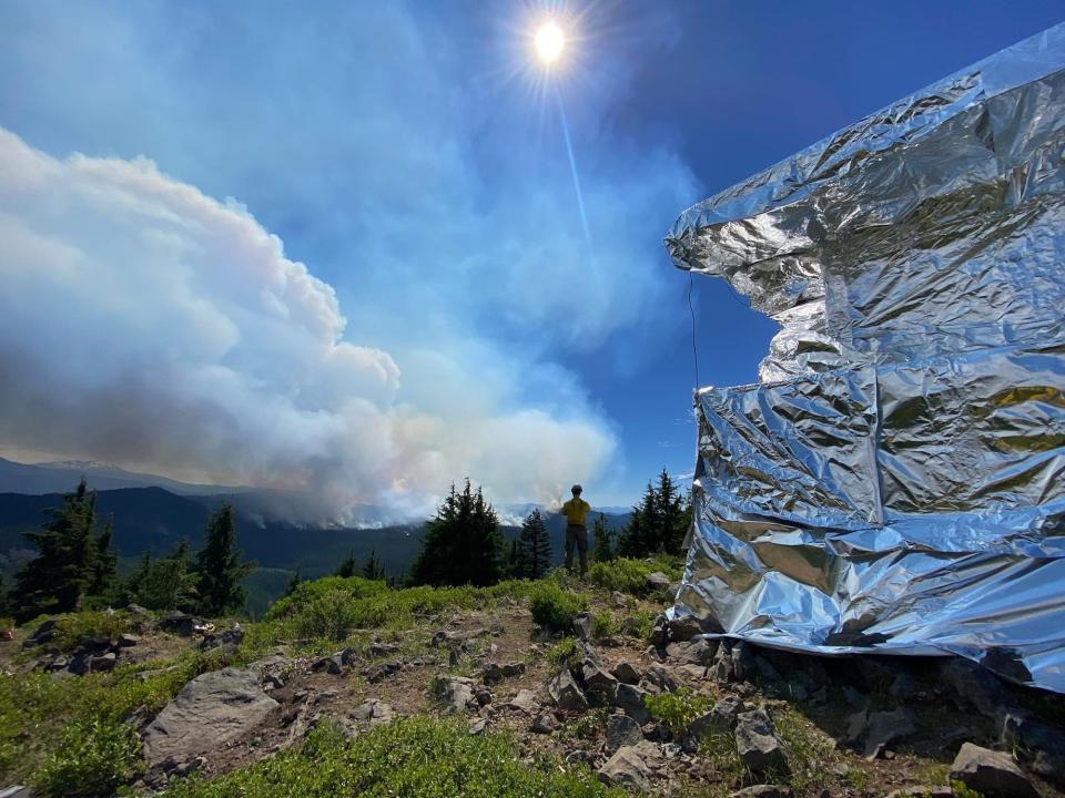 Firefighters use an aluminum-based wrap for structure protection on the Waldo Mountain Lookout east of Oakridge, Ore. Firefighters are making use of this vantage point to monitor and track the Cedar Creek Fire's movement. 