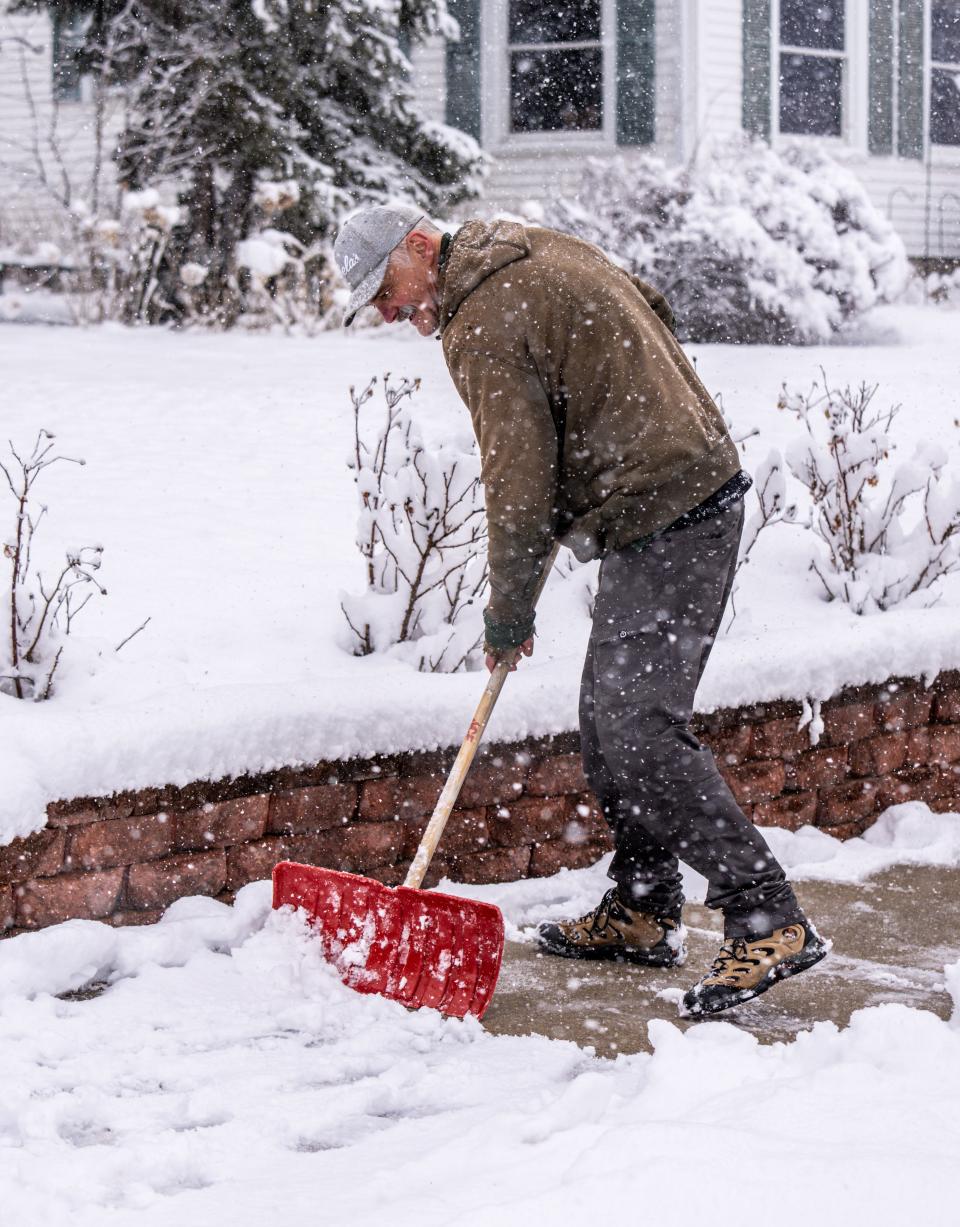 David Moll of Pewaukee clears snow for his neighbors during the snow storm Saturday, March 25.