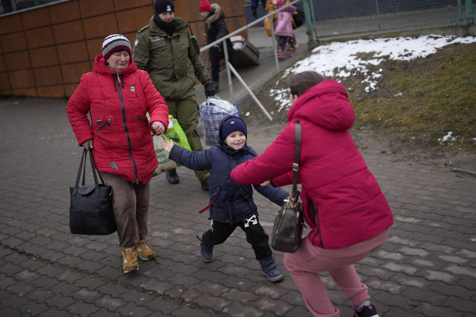 Ina Karpanko, who lives in Poland, right, reunites with her son Vanya and his grandmother, who is fleeing the war from neighboring Ukraine at the Medyka border crossing, Poland, Wednesday, March 9, 2022. (AP Photo/Daniel Cole)